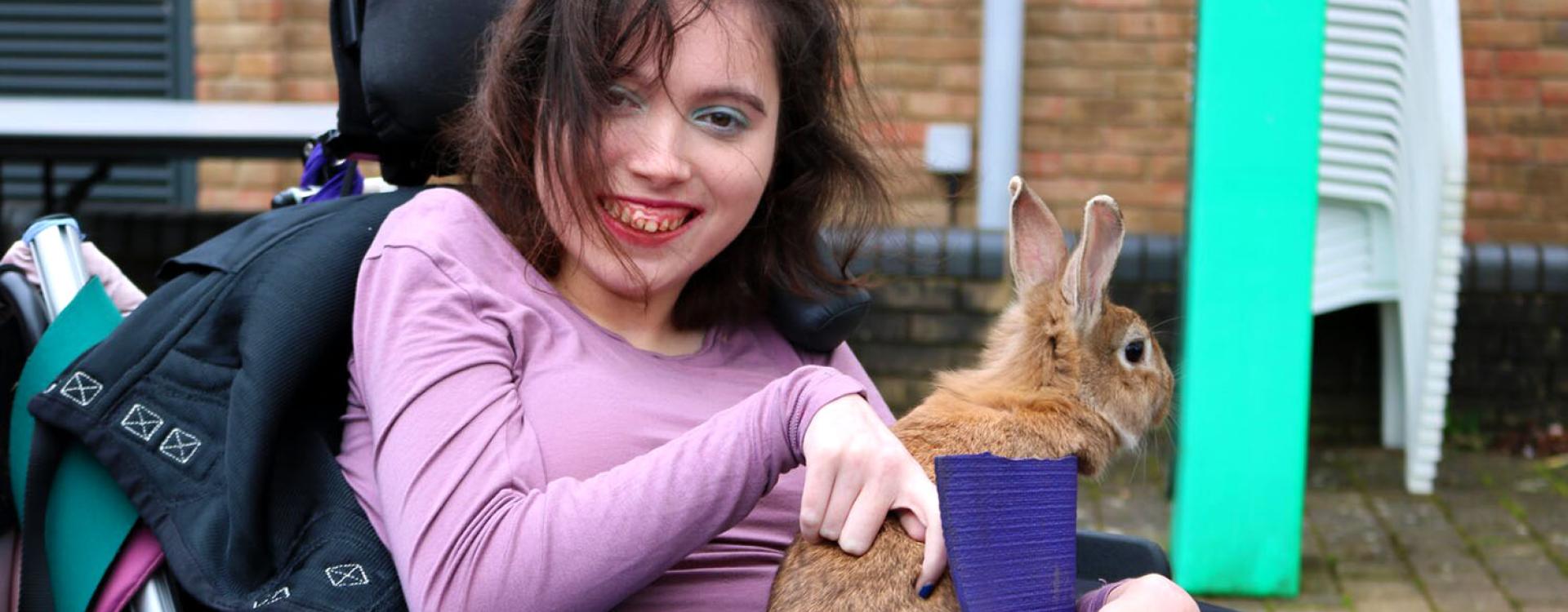 Treloar's student looking at the camera and holding a brown bunny; she is smiling