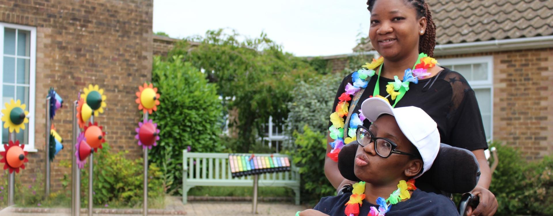 Treloar College student is posing for a photo with her assistant outdoors. They are both wearing flow