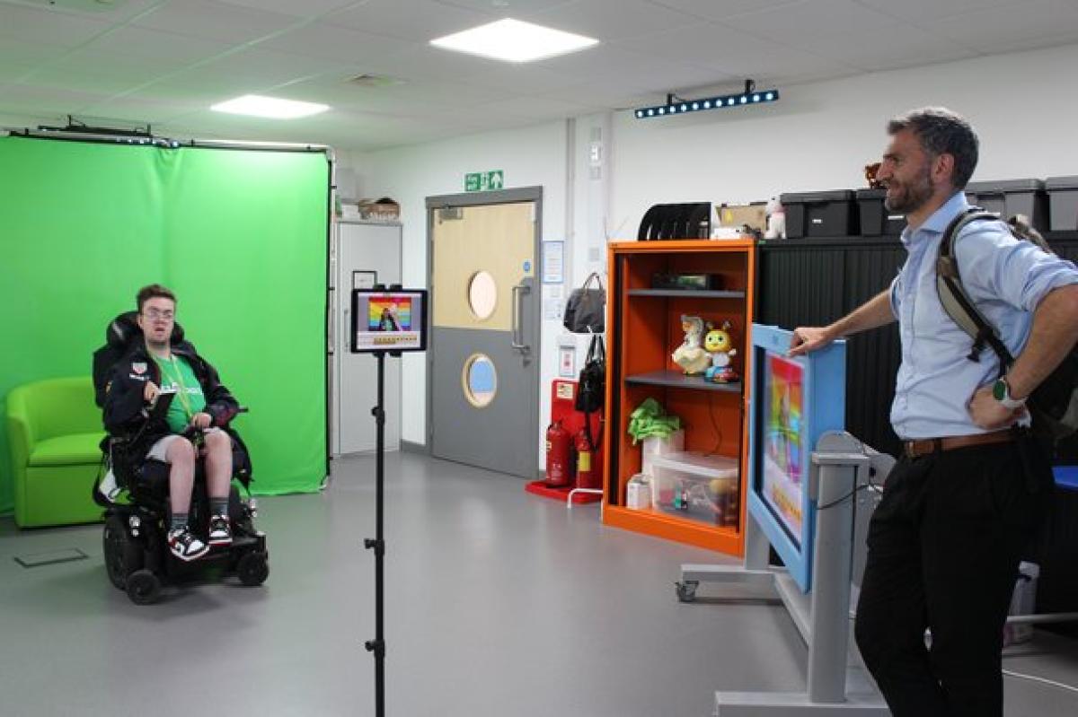 Donor listening to the presentation about the green screen area by Treloar's student demonstrating how to use the screen.