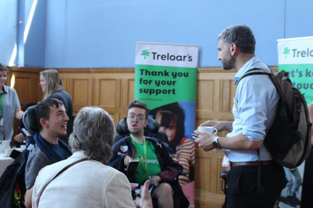 Treloar's students talking to visitors at Treloar's event. Treloar's banners in the background.