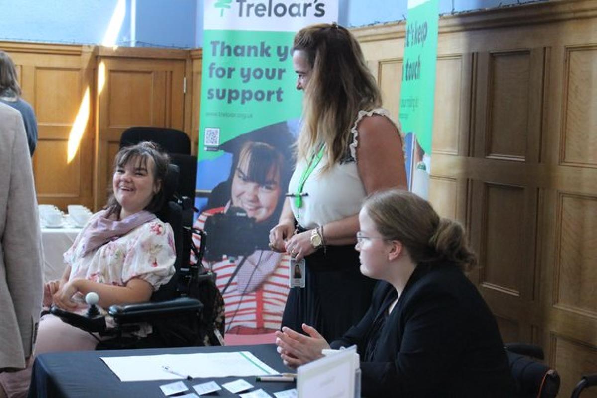 Treloar's students at a registration desk during Treloar's event. Treloar's banners in the background.