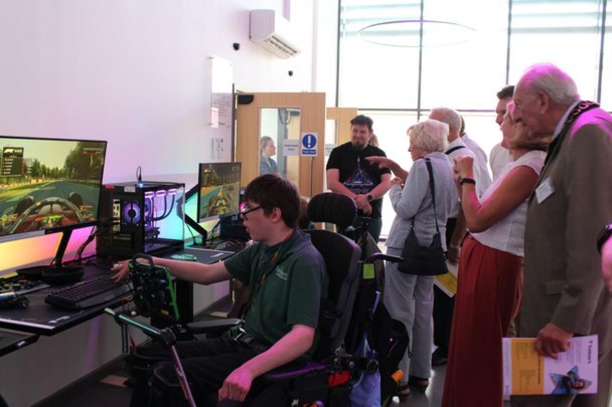 Treloar's student demonstrating the eSports to donors: he is playing a computer games, while donors are watching and discuss the growing sector of eSports