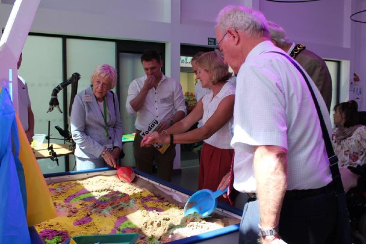 Donors at the official opening of the new Bradbury Learning Centre; all gathered around the interactive sand pit and listening to the demonstration.