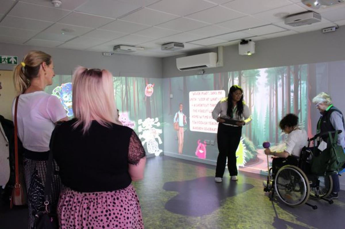 Treloar's student demonstrating how the Immersive Room works; donors are watching the presentation.