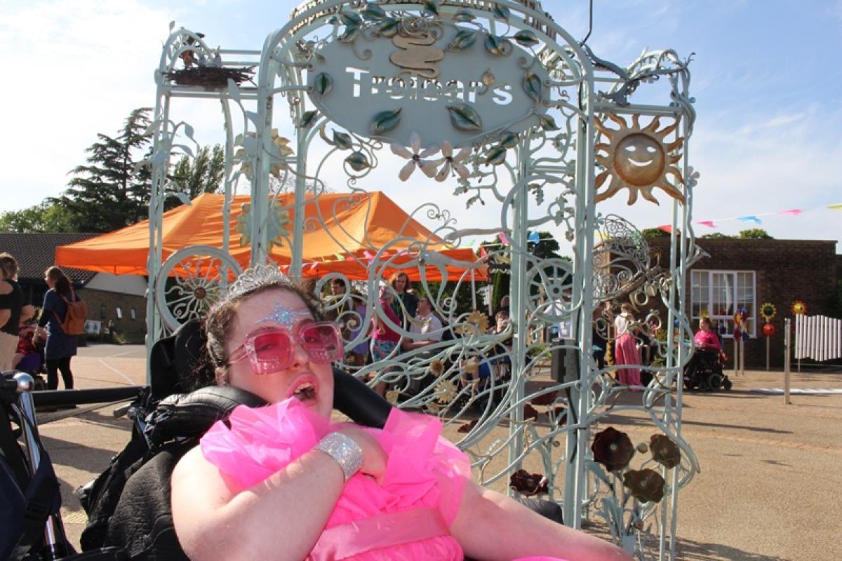 Treloar College student wearing a bright pink tulle gown on her prom night. She is wearing big pink sunglasses and a tiara.