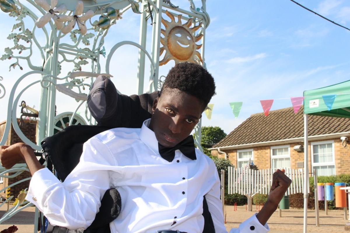 Treloar College student wearing a white shirt and a black bow tie on his prom. He his outdoors, it is a sunny day.
