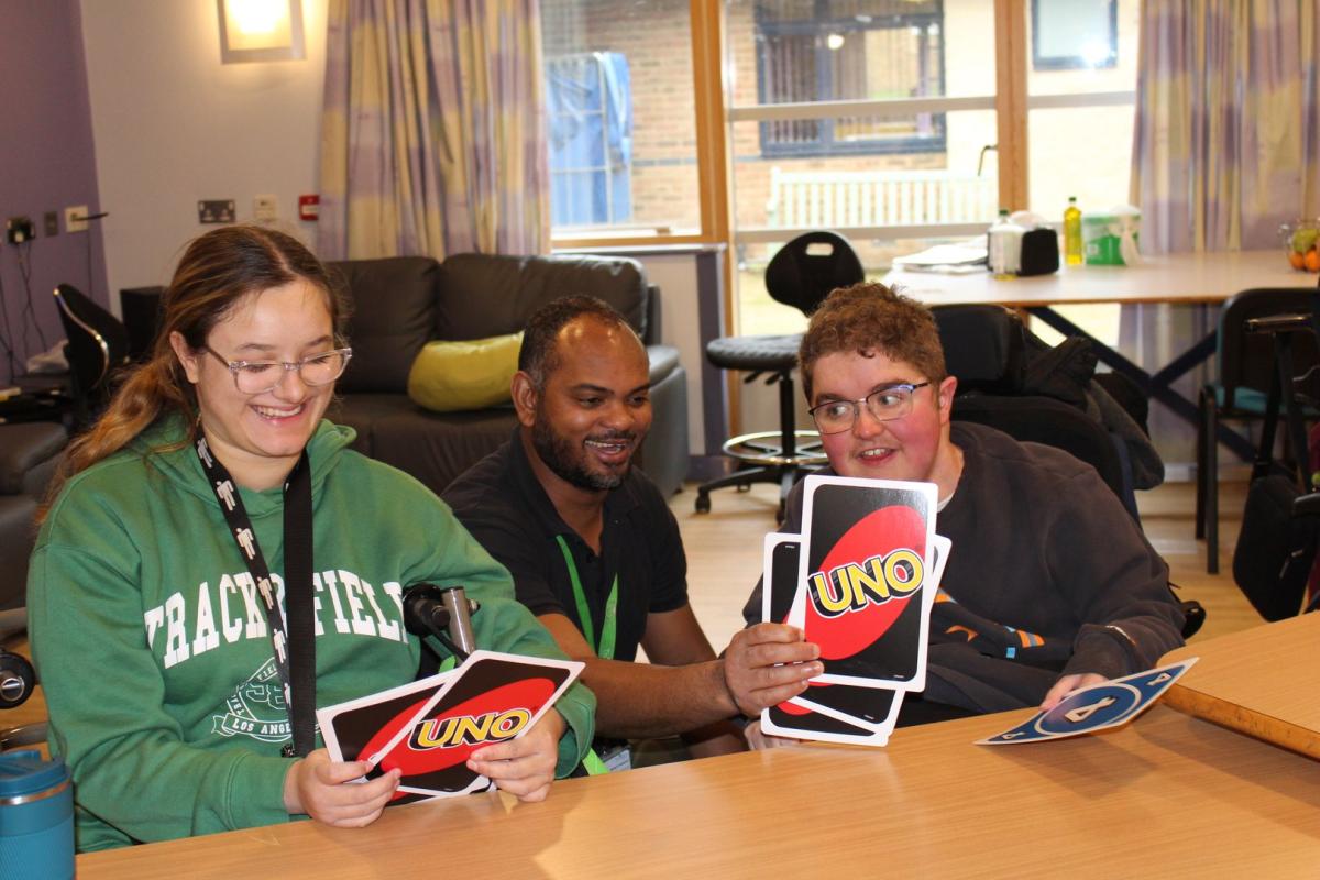 Two students playing Uno card game together