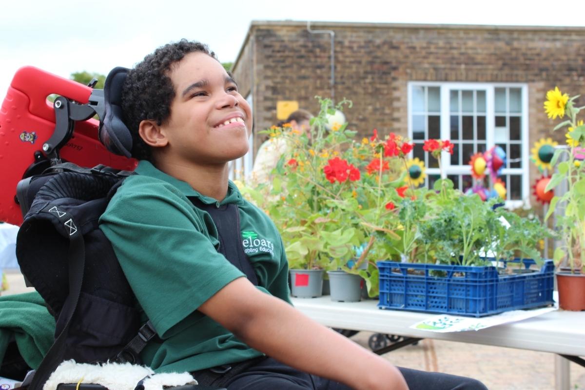 Treloar's student smiling with poppies and red and yellow plants behind them