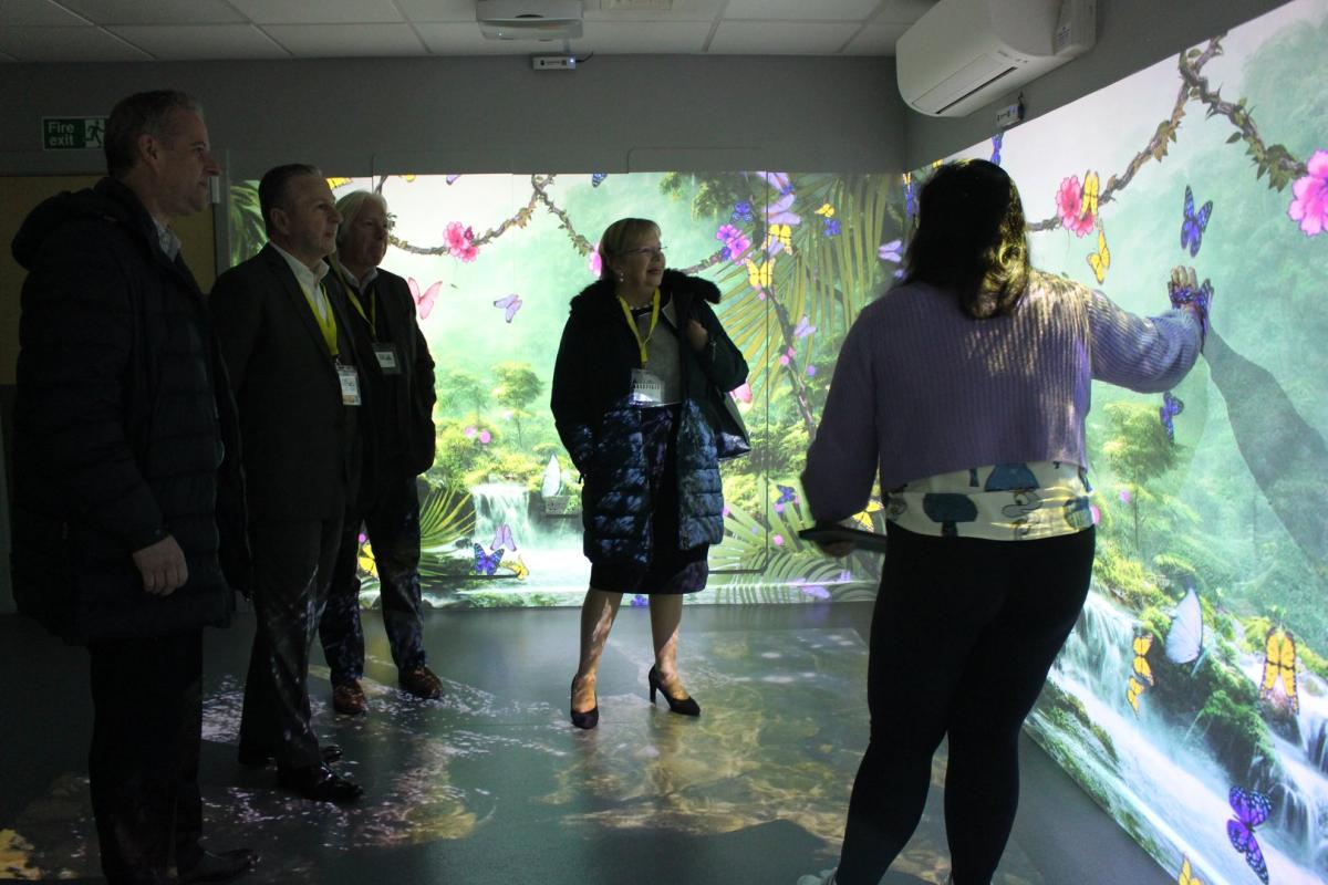 A group of professional visitors are shown the immersive learning zone at Treloar's