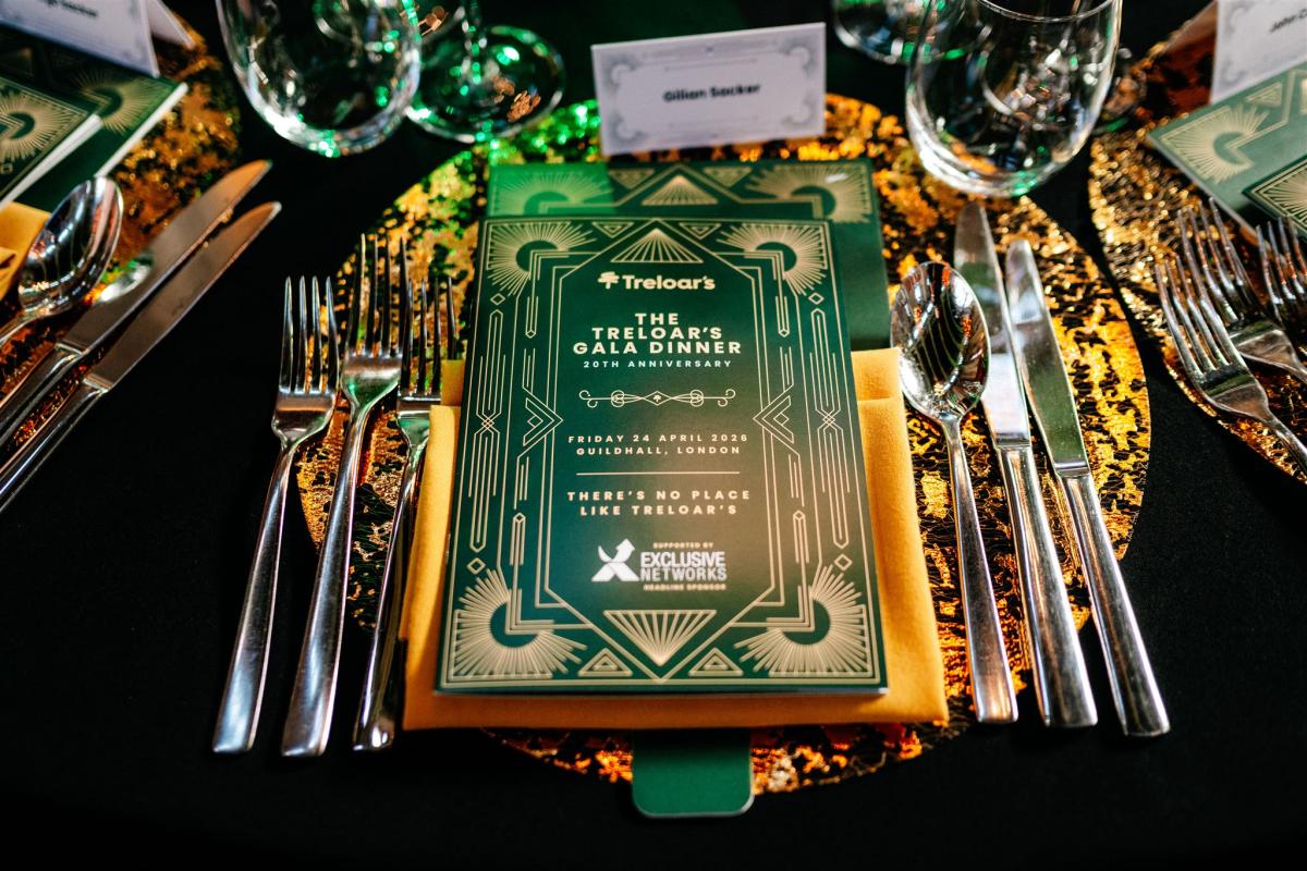 Table setting with event programme, cutlery and glasses 