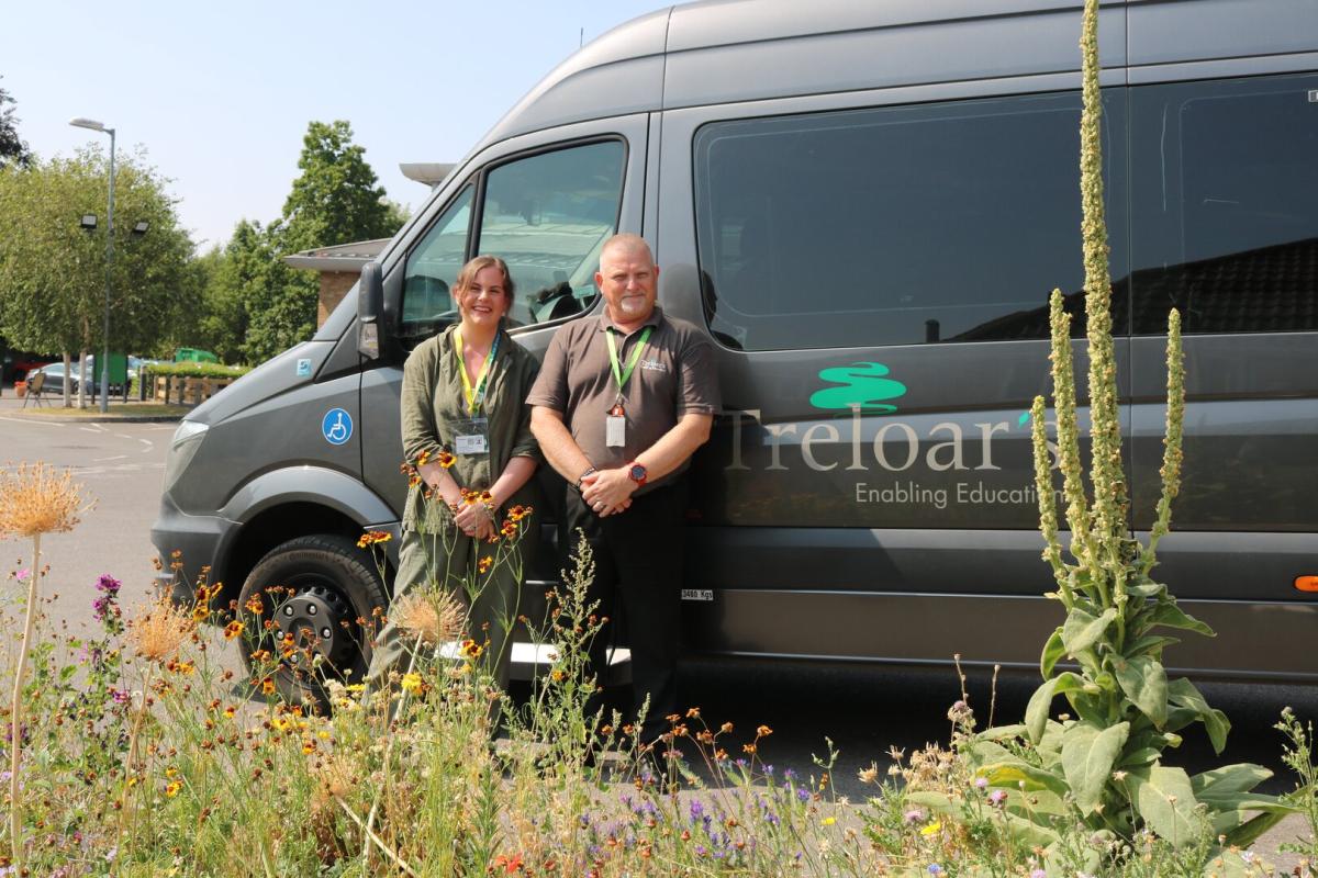 a man and a woman stand beside Treloar's minibus