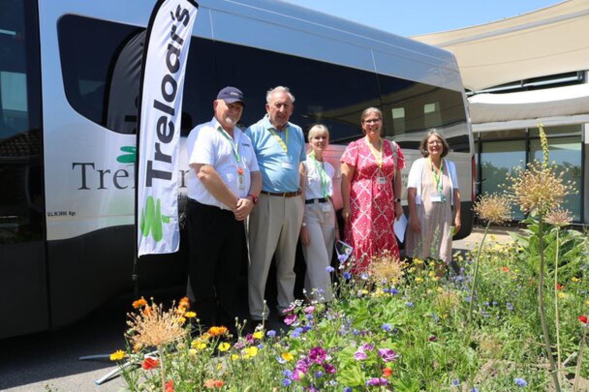 A group of EHDC councillors stand beside a Treloar's minibus