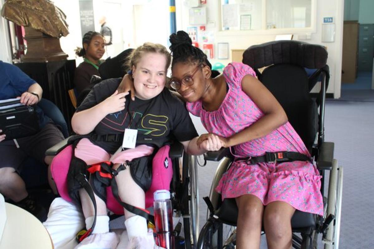 Two female students in wheelchairs smiling together