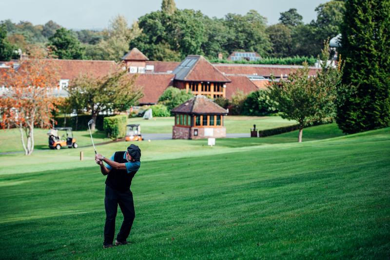Golfer in mid-swing at Old Thorns golf club
