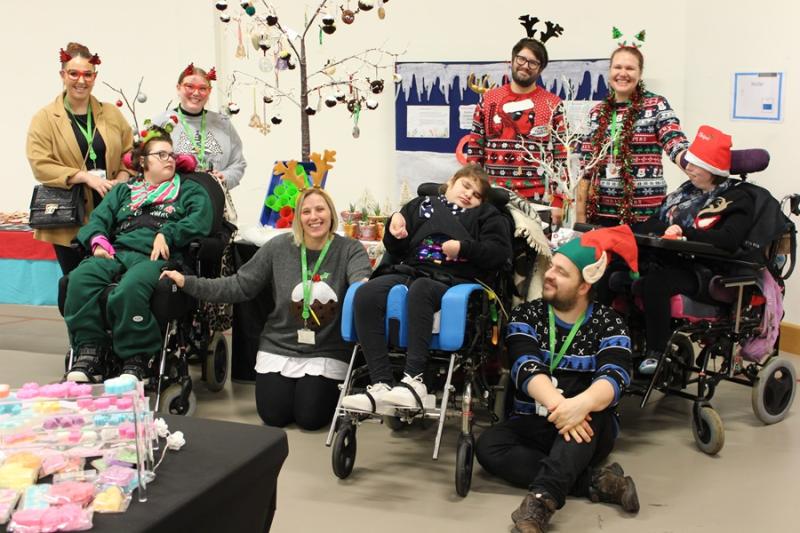 Treloar's students and staff at Christmas Fair wearing Christmas hats and jumpers.