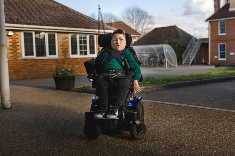 School student Freddie is seated in his powerchair outside Treloar's reception