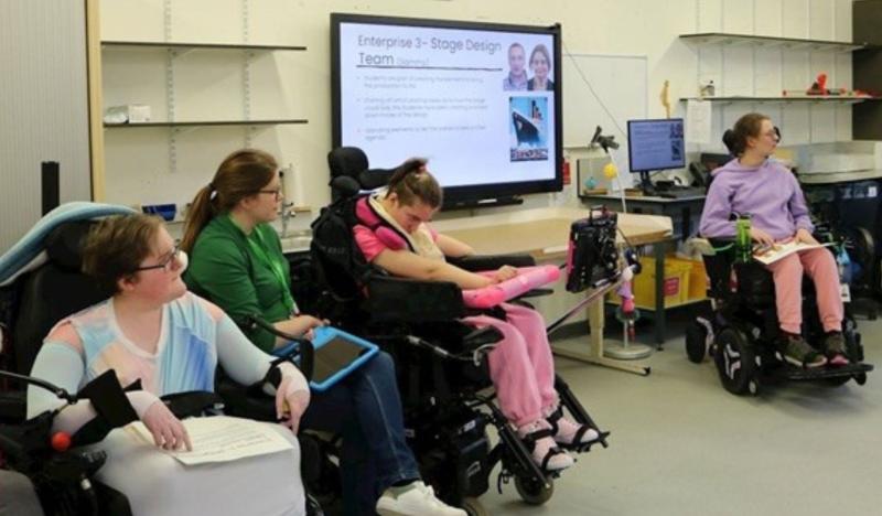 Treloar's students participate in a classroom session present their presentation displayed on a large screen.