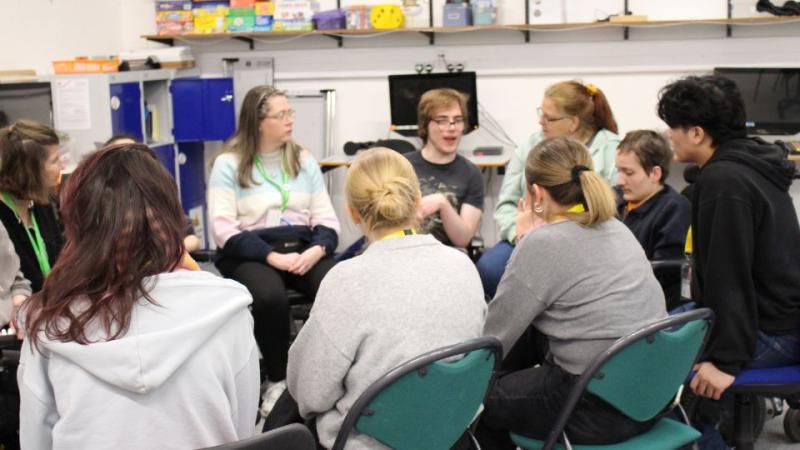  Treloar's staff and students and student nurses sitting in a circle in a classroom engaged in a discussion or group activity.