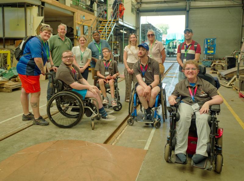 A group of students in wheelchairs in the Ropley engine sheds