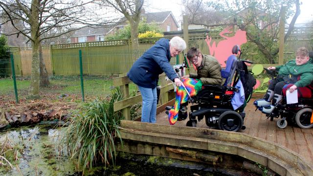 Treloar School students by the pond taking part in a pond dipping activity.