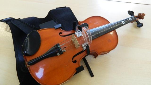 A violin with a black strap.
