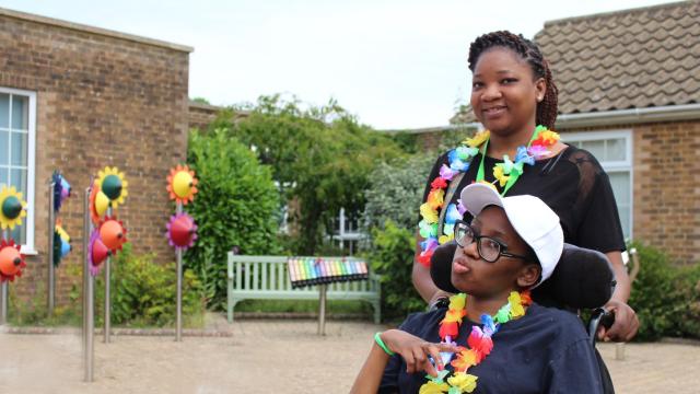 Treloar College student is posing for a photo with her assistant outdoors. They are both wearing flow