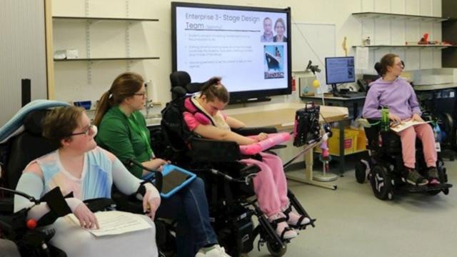 Treloar's students participate in a classroom session present their presentation displayed on a large screen.