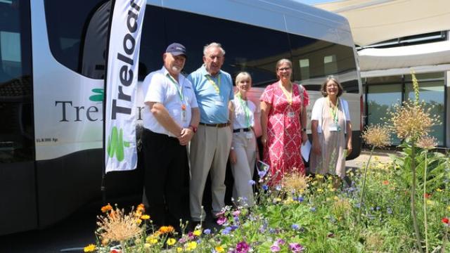 A group of EHDC councillors stand beside a Treloar's minibus