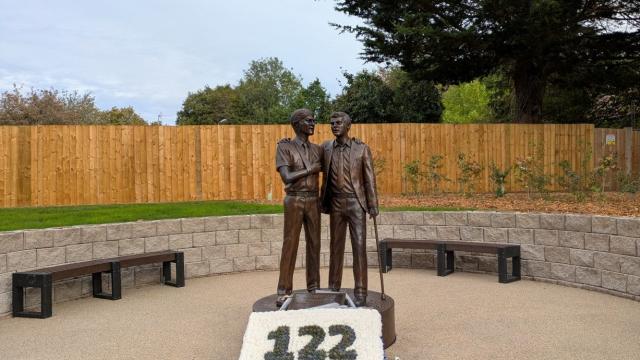 Treloar's Memorial to students affected by infected blood, a bronze statue of two boys, with a floral tribute at the base, in memory of the students who died following the treatment they received.