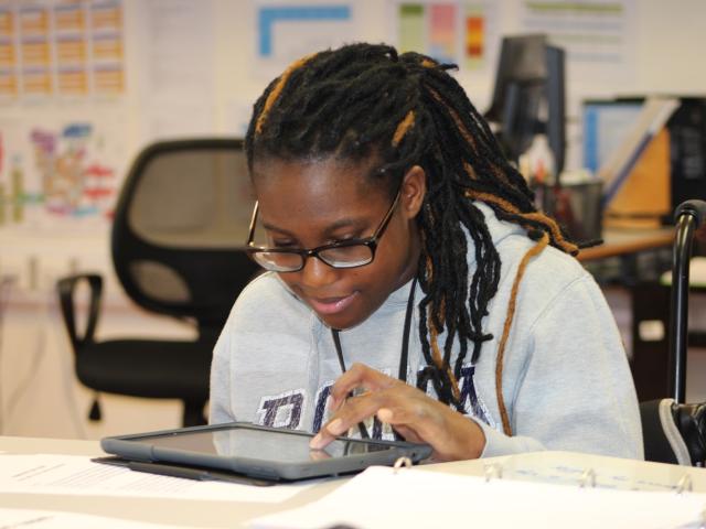 Treloar College student Delali is using an iPad, taking part in work experience