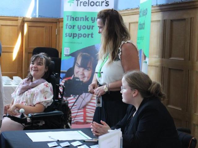 Treloar's students at a registration desk during Treloar's event. Treloar's banners in the background.