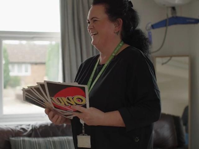 Deputy team leader Sarah holding over sized UNO cards
