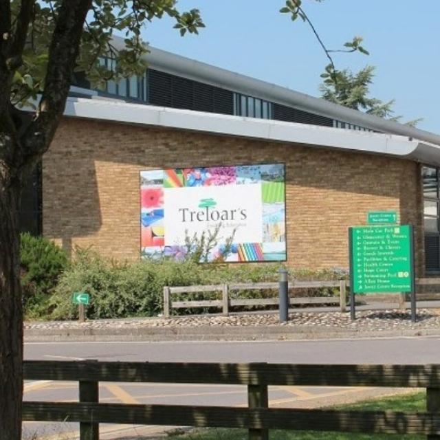 The front of Treloar's building seen from the driveway; a big logo of Treloar's attached to the wall.
