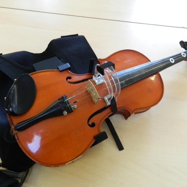 A violin with a black strap.