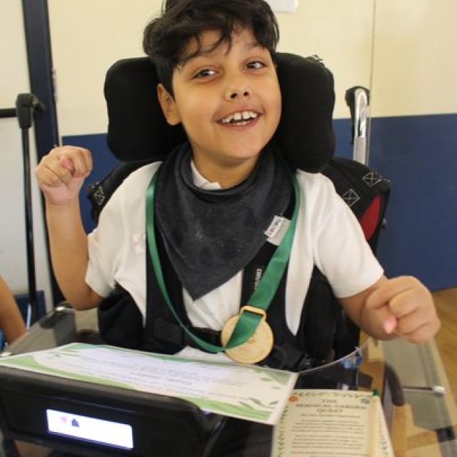 School student with medal and prize certificate smiling