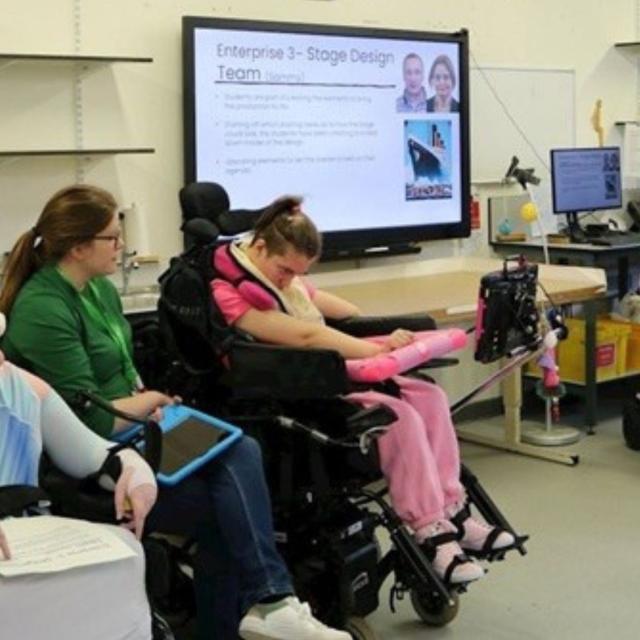 Treloar's students participate in a classroom session present their presentation displayed on a large screen.