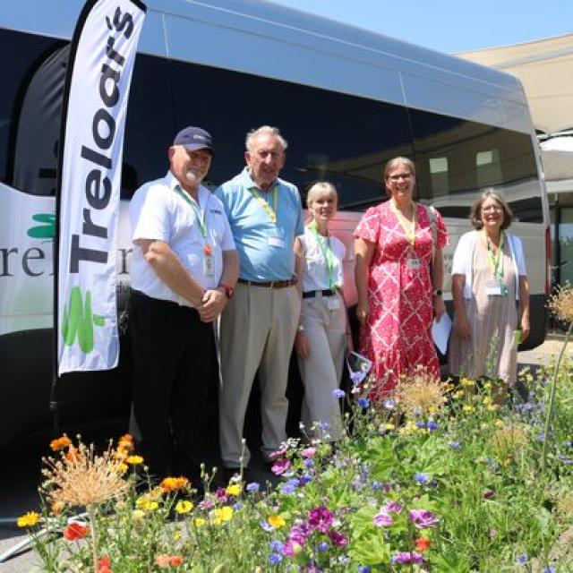A group of EHDC councillors stand beside a Treloar's minibus