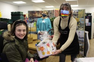 Treloar's student Daisy handing over Harvest donation to Alton Community Cupboard