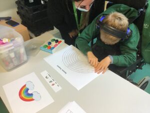 student colouring in a rainbow