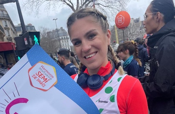 Lucy ready to run Paris half marathon holding a banner with her name on it
