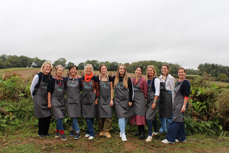 The Dummer Fair Committee with Treloar's Events Team in a group shot all wearing Treloar's aprons with the fields in the background