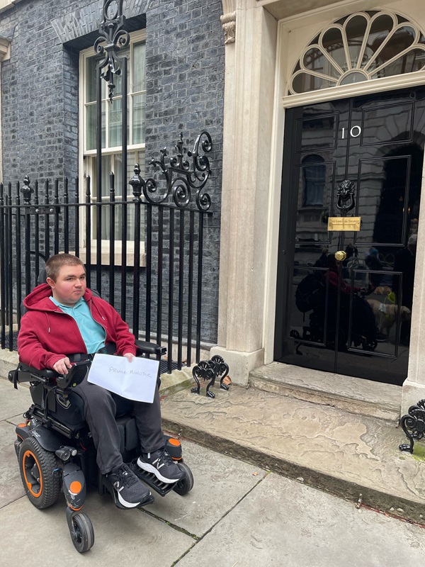 Treloar College student Ben outside Number 10 Downing Street, holding the petition
