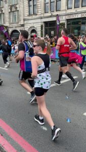 Treloar's Events Assistant Lauren during the London Marathon: Lauren is running, surrounded by other runners, holding a bottle of water in her hand.