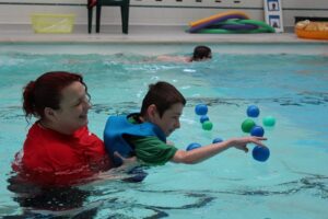 Day of Disability Sports at Treloar's: students in the pool fishing out plastic balls